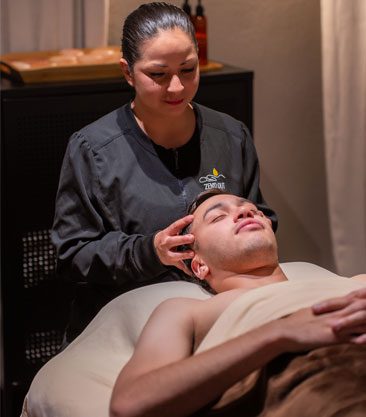 father-day-page-so-img A woman relaxing while receiving a single massage hot stone treatment on her back.