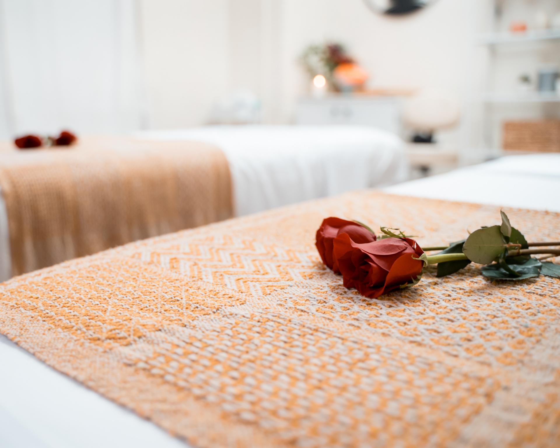 A red rose placed on a prepared massage table at Zen'd Out