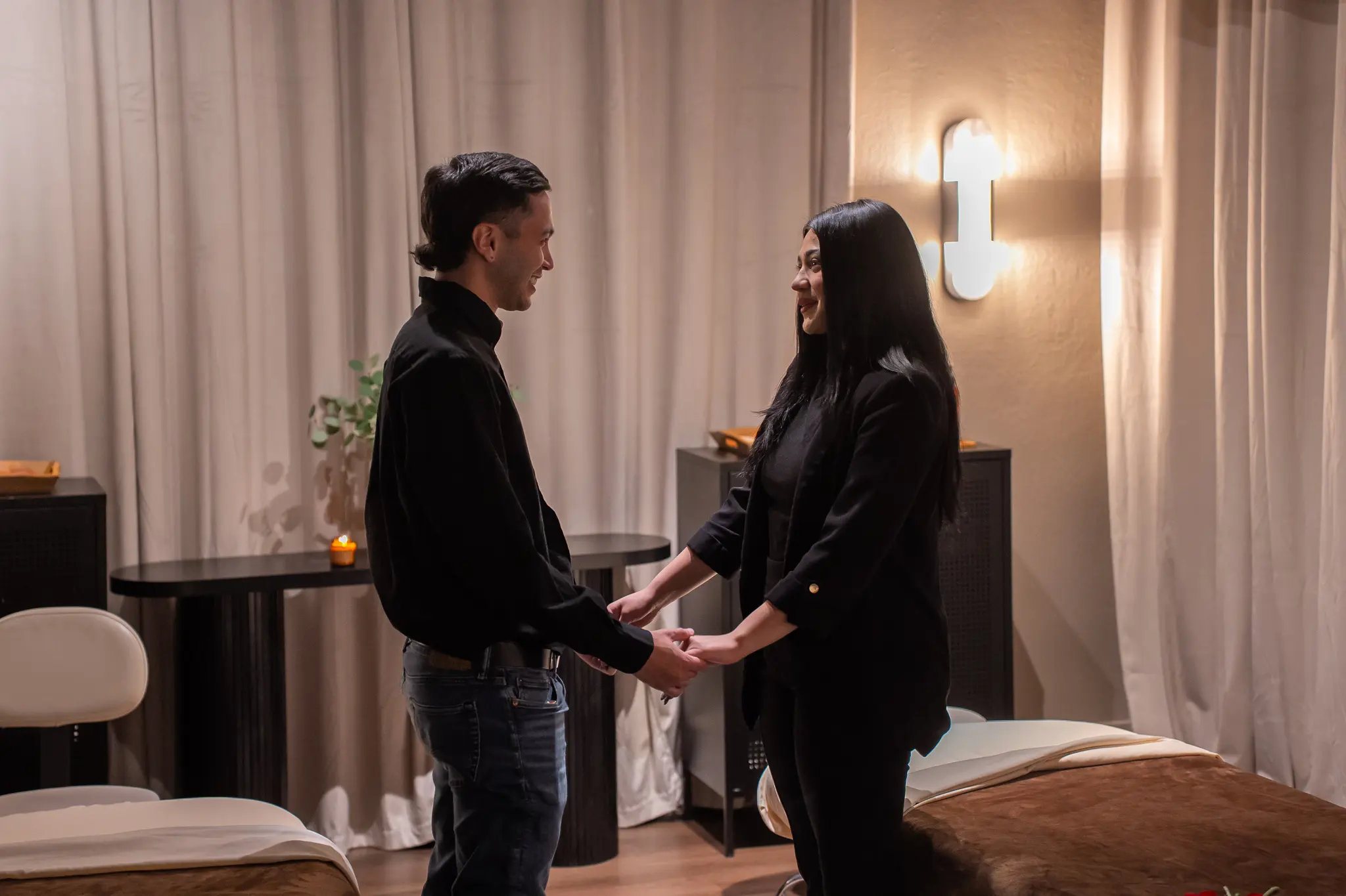 A couple holding hands and sharing a quiet moment in a Zen'd Out couples suite