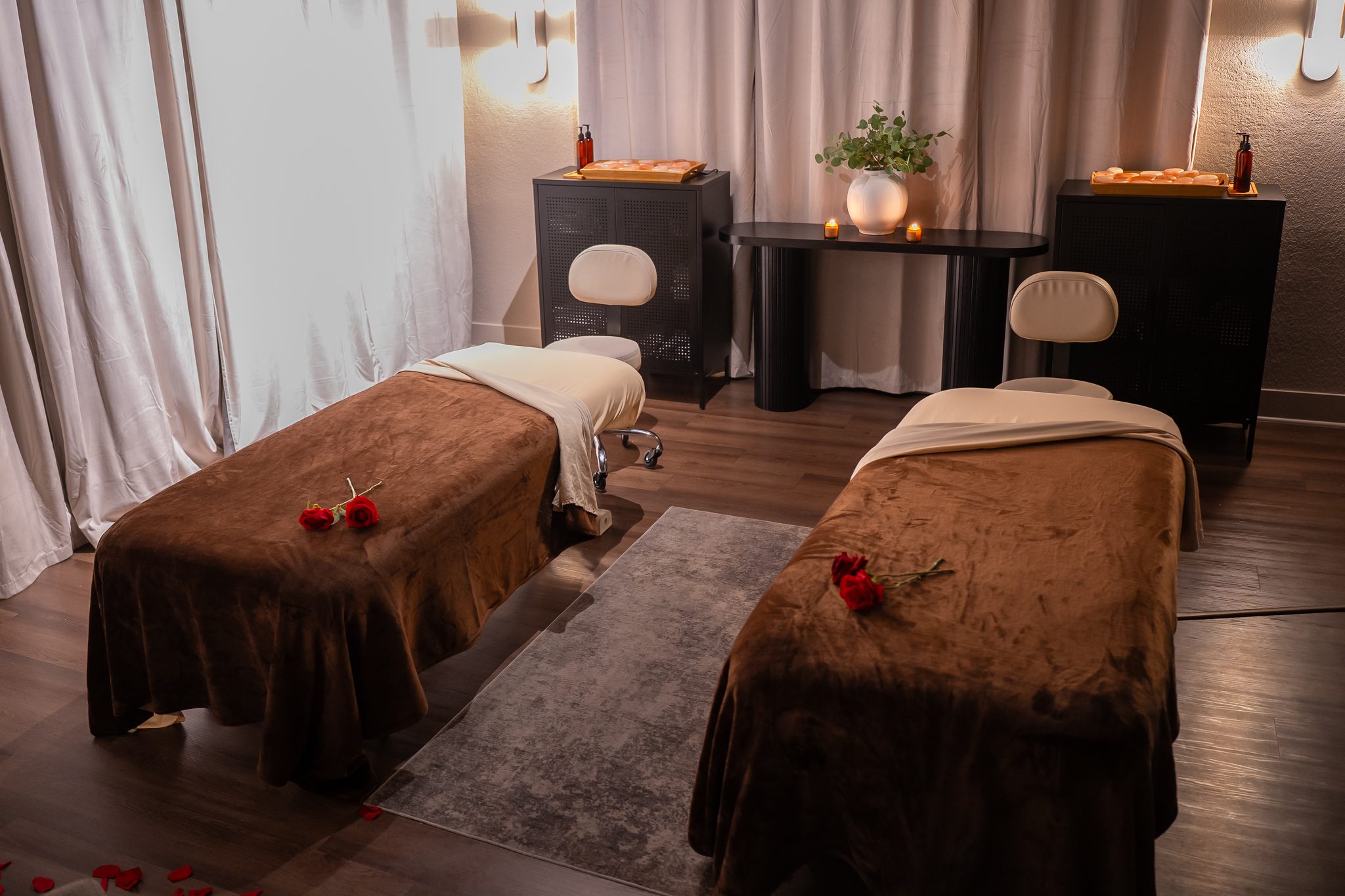 Two massage tables with roses in a private couples suite at Zen'd Out Englewood